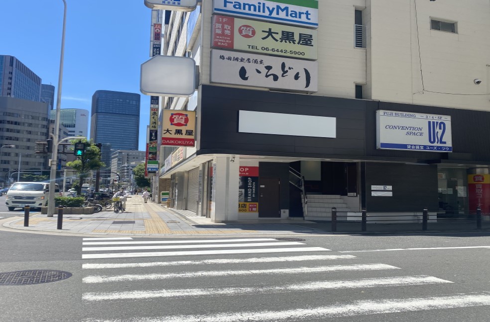 「ファミリーマート西梅田店」の方面に横断歩道をお渡りください。