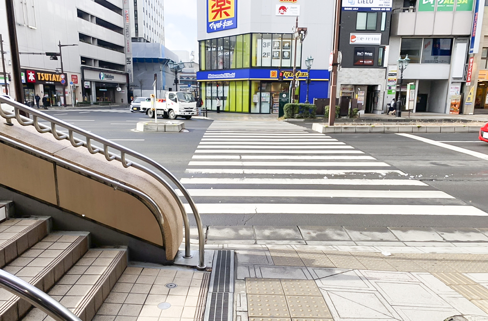 階段をおりてすぐ左手に横断歩道がございます。「薬マツモトキヨシ仙台駅前店」のある方に向かって直進してください。
